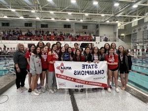 Girls' swim team celebrating state championship victory.